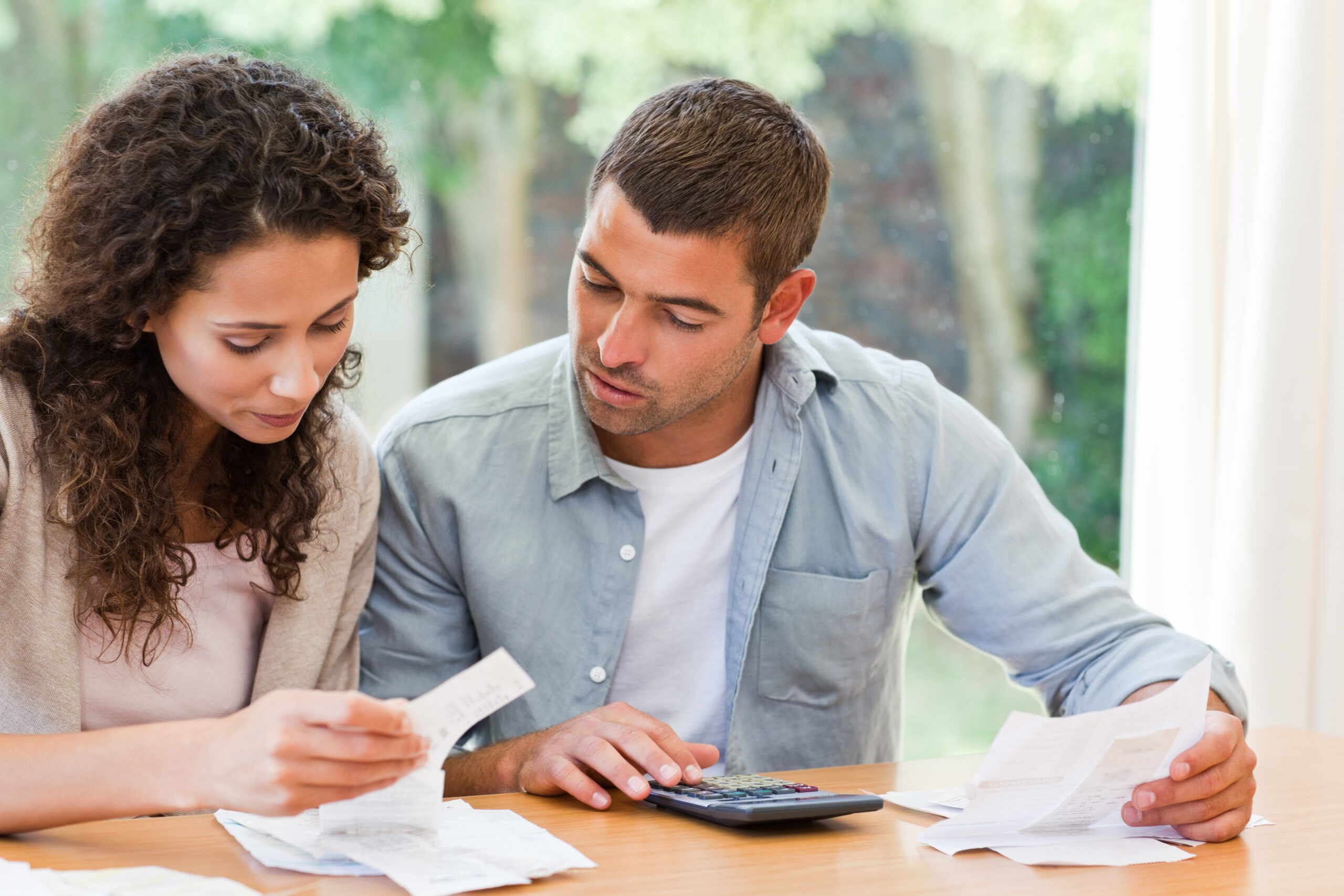 changing health insurance, Young,Couple,Calculating,Their,Domestic,Bills,At,Home