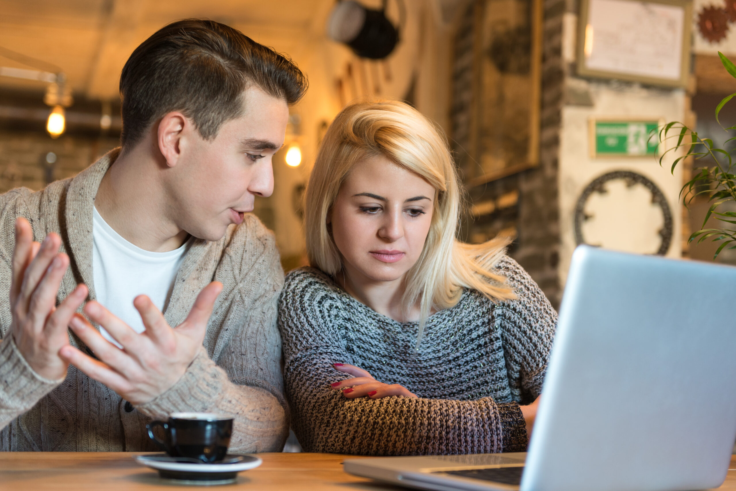 Young,Couple,Sitting,In,The,Cafe,With,Laptop,Making,Some