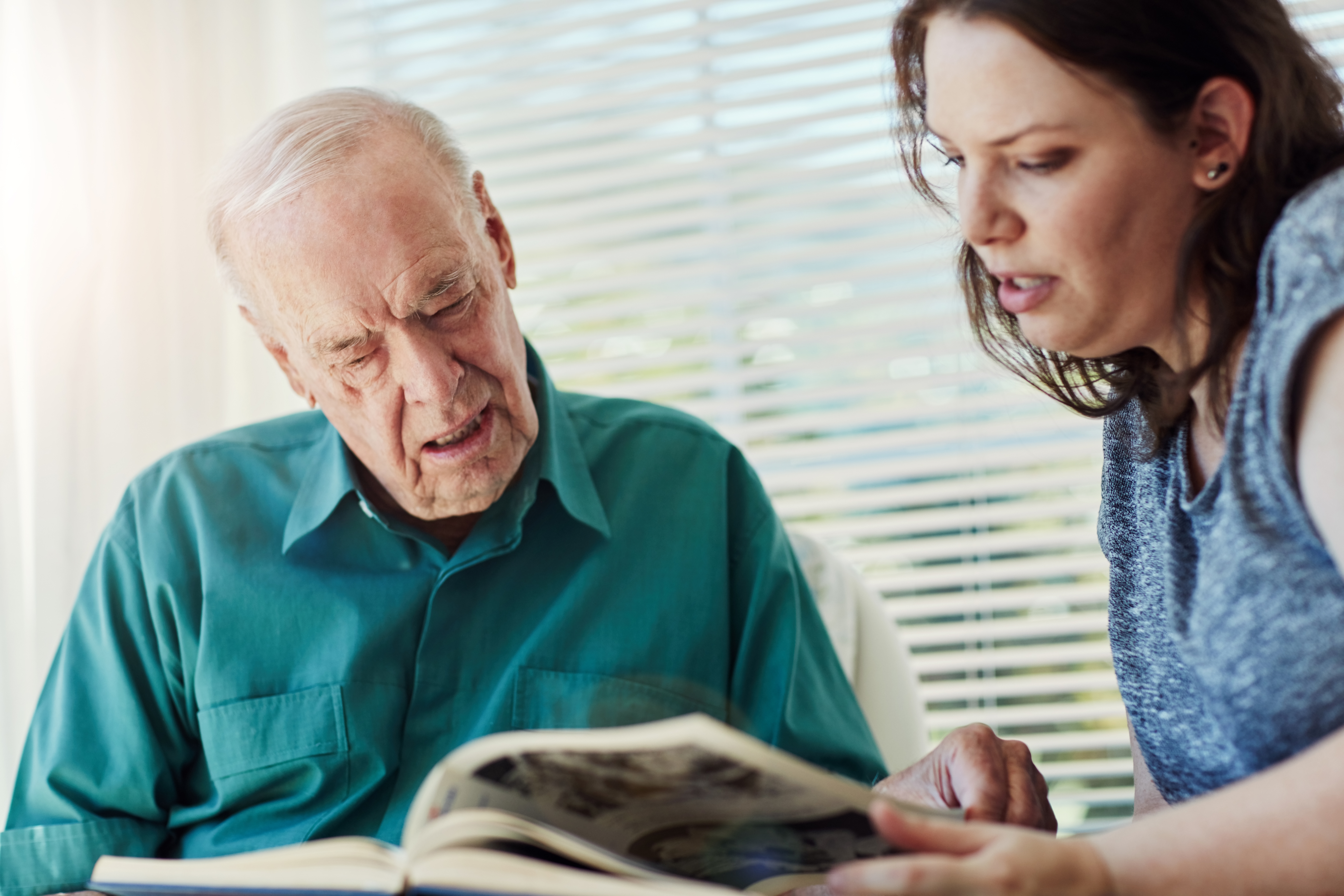 Elderly,Father,,Daughter,And,Looking,At,Photo,Album,With,Retirement,