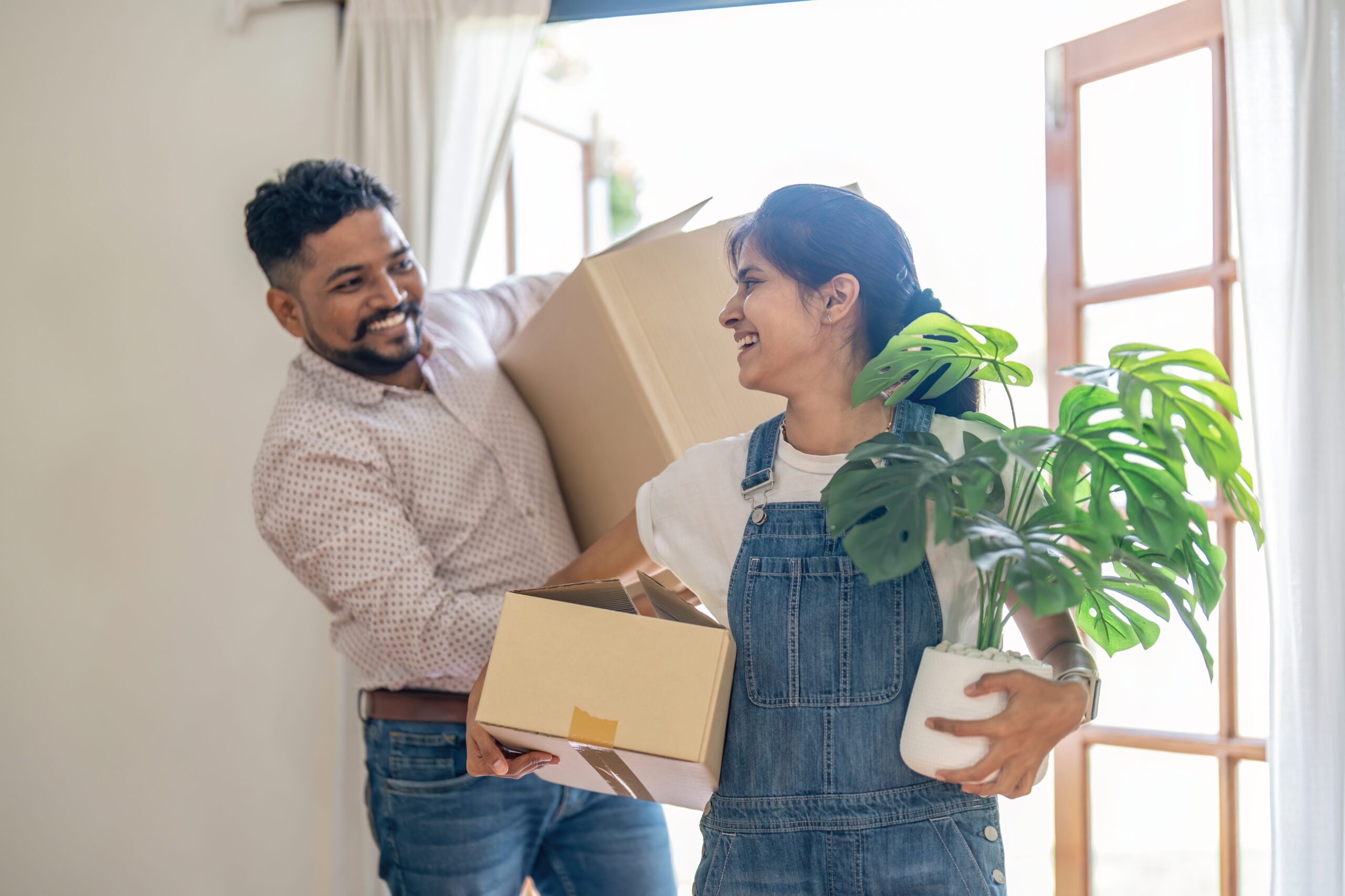 Couple,Indian,Happy,Carrying,Box,On,Moving,Day,In,Of