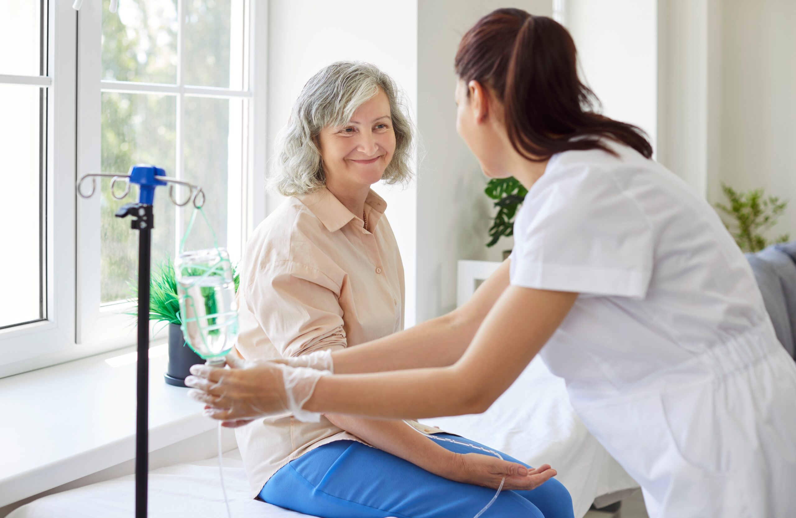 Senior,Woman,With,Intravenous,Drip,Sitting,On,Medical,Couch,,Physician,