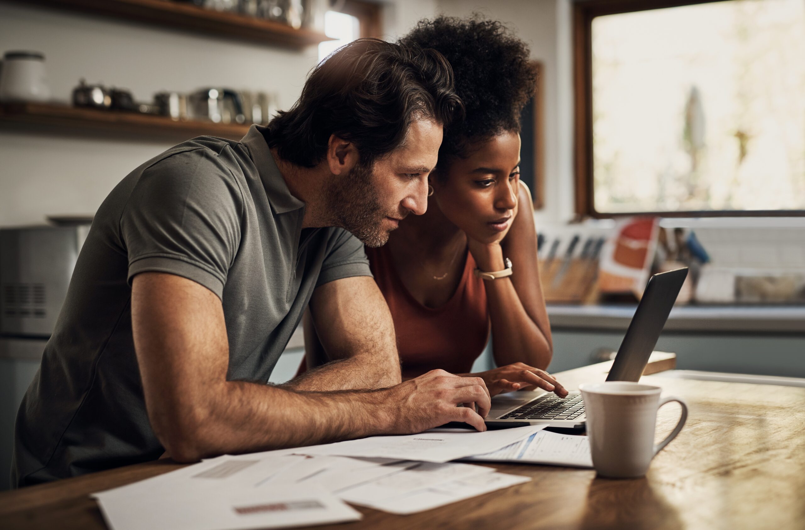 Couple,With,A,Laptop,Doing,Finance,Paper,Work,,Paying,Debt